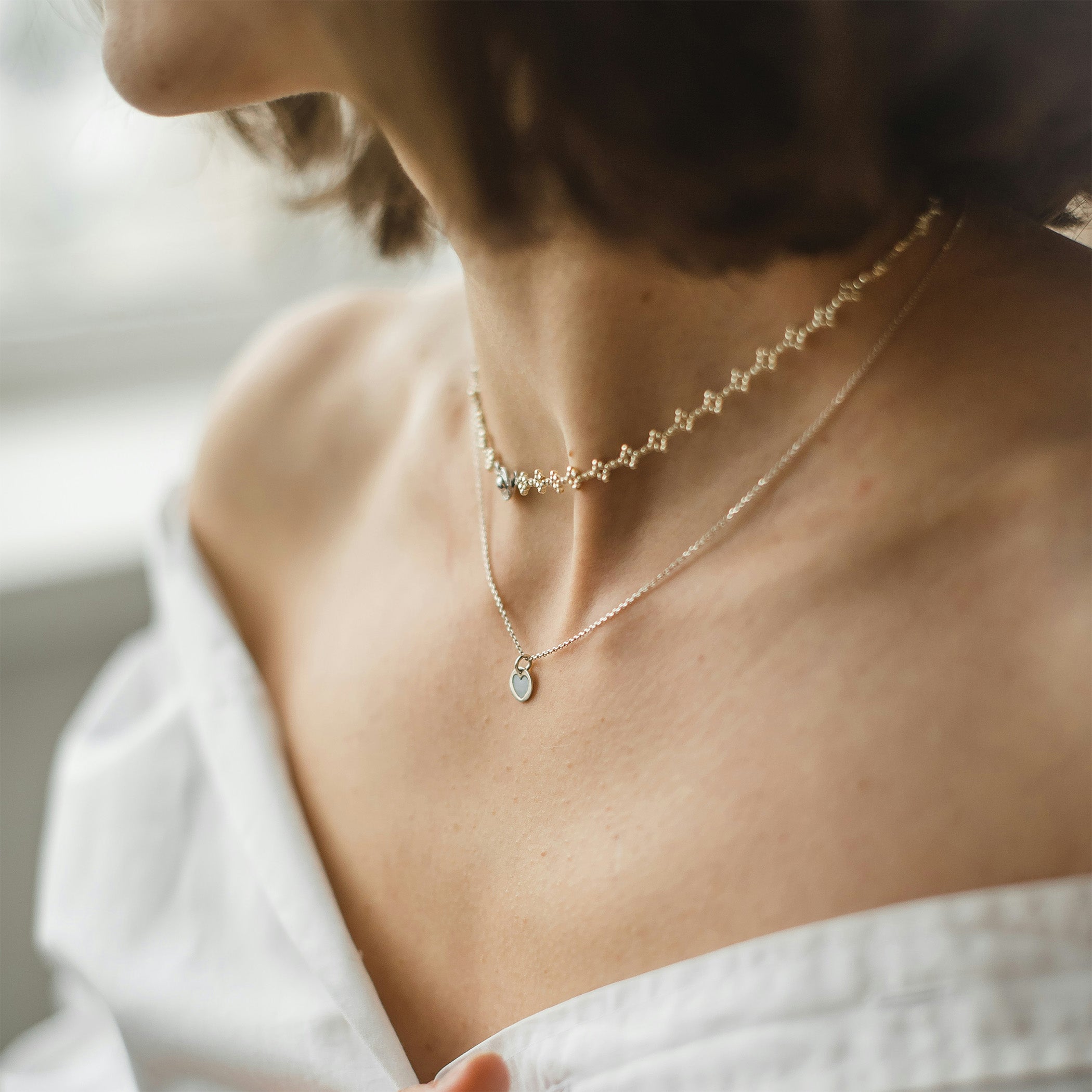 A lady wearing gold necklaces