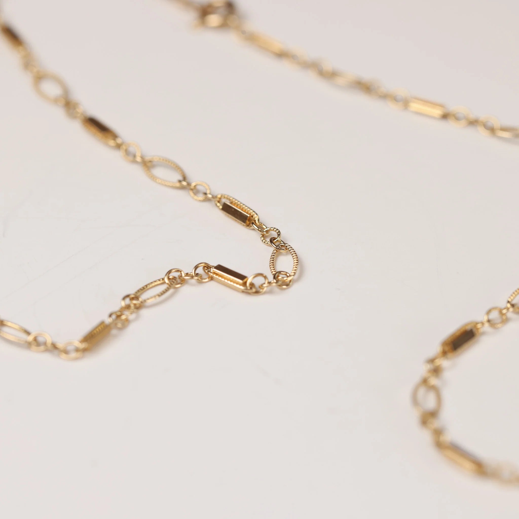 A beautiful gold necklace on a white background.