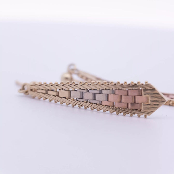 A 14 Karat Yellow Gold White Stone Tennis Bracelet with a woven pattern.