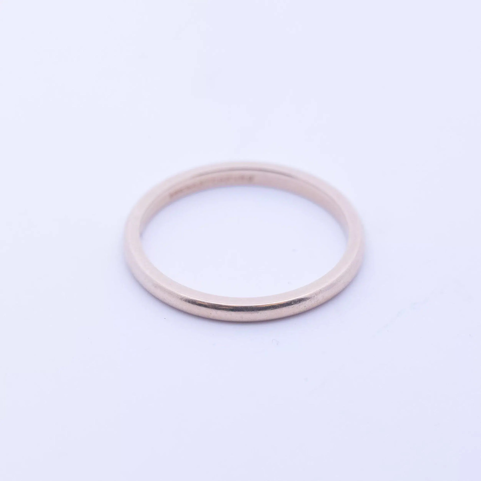 A 14 Karat Yellow Gold Band on a white background.