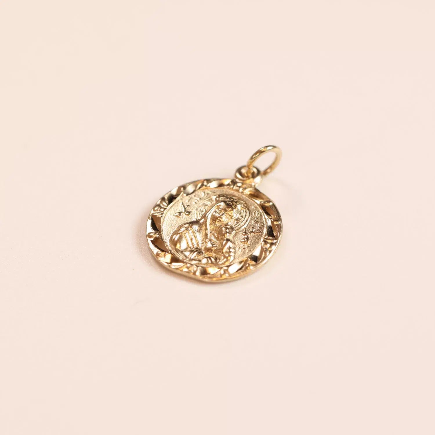 14 Karat Yellow Gold Figaro 25" Chain pendant with embossed design on aplain background.