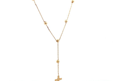 A gold - plated cross necklace on a white background.