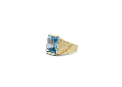 A gold ring with a blue topaz stone.