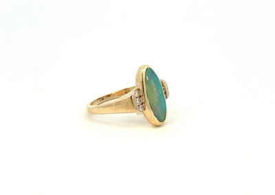 A gold ring with a turquoise stone and diamonds.