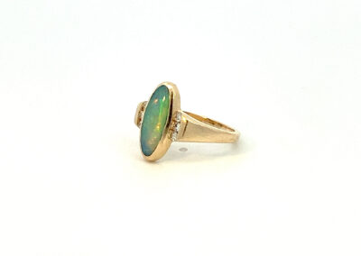 A gold ring with a green opal stone.