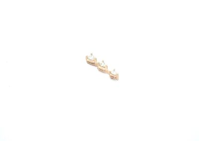 A pair of gold stud earrings on a white surface.