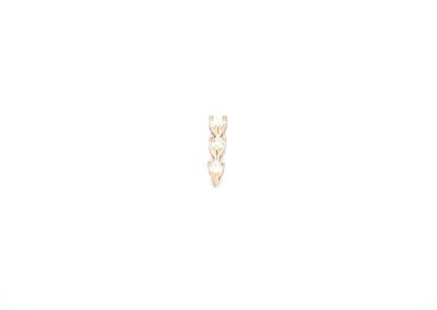 A gold heart shaped stud earring on a white background.