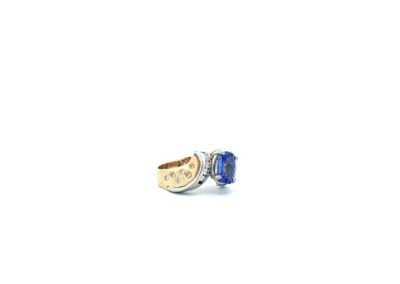 A blue sapphire and diamond ring on a white background.