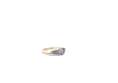A yellow gold ring with blue sapphires.