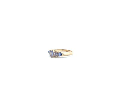 A gold ring with blue sapphire stones.