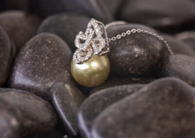 A 14 Karat White Gold Pearl Diamond Necklace with diamonds on a black background.