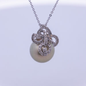 A 14 Karat White Gold Pearl Diamond Necklace on a white background.