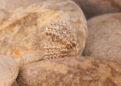 A 14 Karat Yellow Gold White Stone Tennis Bracelet with Diamonds Amidst Rocks.