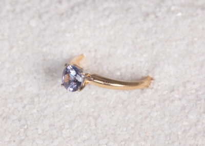 A 14 Karat Yellow Gold White Stone Tennis Bracelet with a blue sapphire.