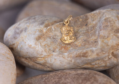A 14 Karat Yellow Gold White Stone Tennis Bracelet resting on some rocks.