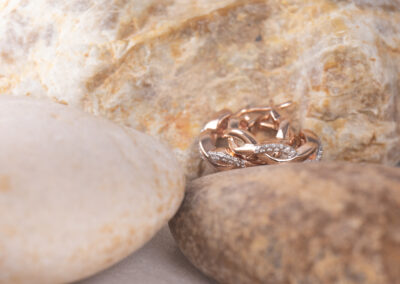 A 14 Karat Yellow Gold White Stone Tennis Bracelet is delicately placed on a smooth rock.