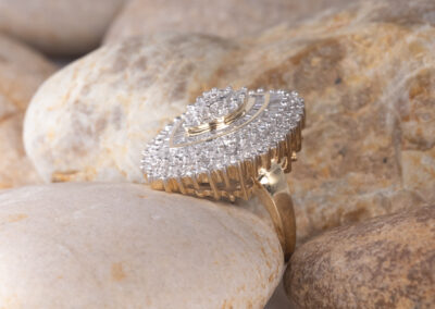 A 14 Karat Yellow Gold White Stone Tennis Bracelet with Diamonds on top of Rocks.