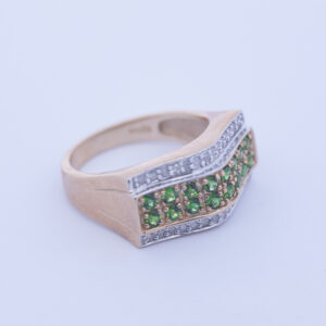 A 14 Karat Yellow Gold White Stone Tennis Bracelet with green peridots and diamonds.