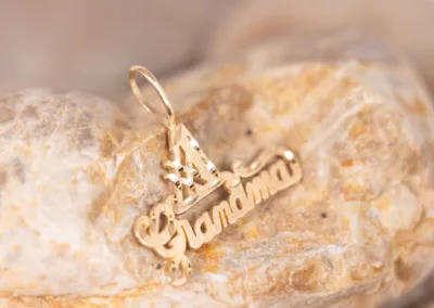 A 14 Karat Yellow Gold Fashion Chain charm with the word grandma on it.