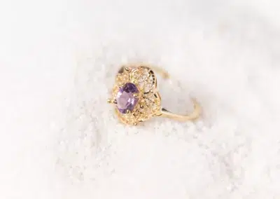 A 14 Karat Yellow Gold Fashion Chain amethyst ring on top of snow.