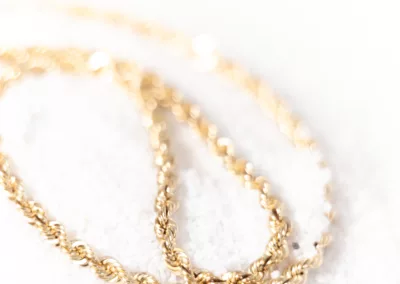 A 14 Karat Yellow Gold Fashion Chain laying on top of snow.