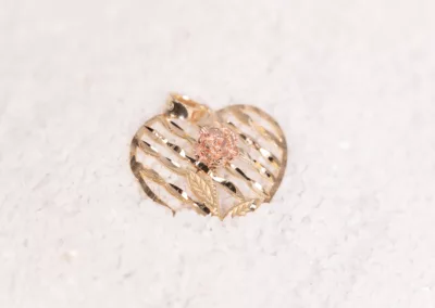 A 14 karat yellow gold fashion chain pendant with a pink stone.