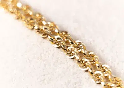A 14 Karat Yellow Gold Fashion Chain, on a white surface.