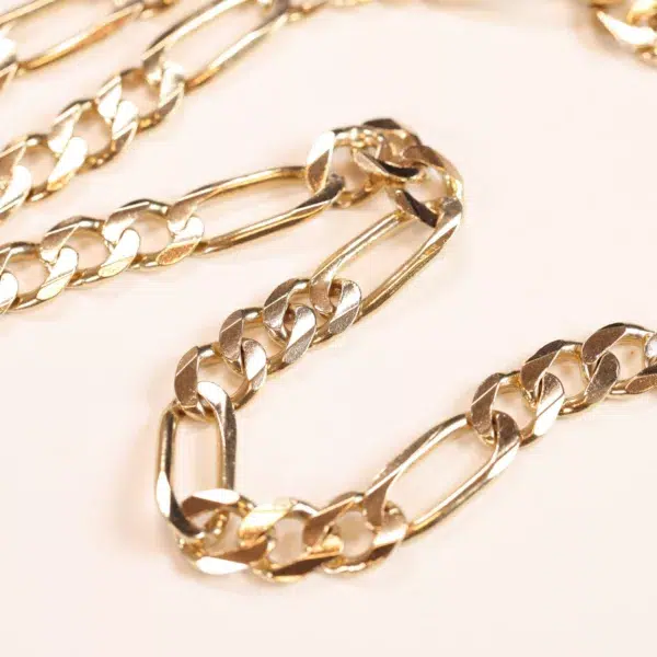 Gold chain necklace on a cream-colored background, AUTO-DRAFT.