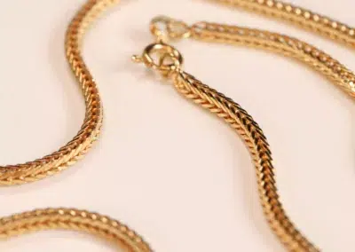 14 Karat Yellow Gold Figaro 25" Chain necklace on a pale background.
