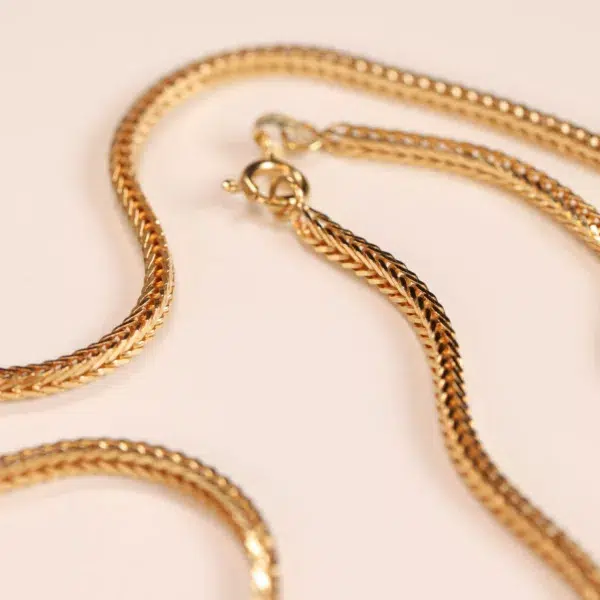 14 Karat Yellow Gold Figaro 25" Chain necklace on a pale background.