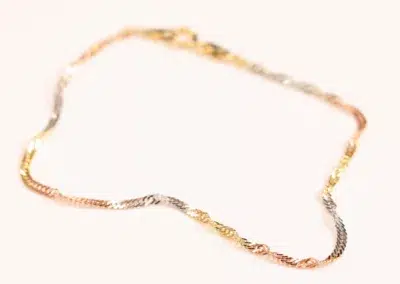 A twisted tri-color 14 Karat Yellow Gold Figaro 25" Chain on a white background.