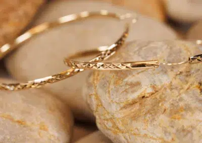 A 14 Karat Yellow Gold Comfort Fit Band on a rock.