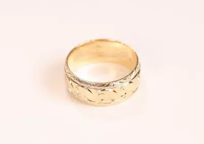 A 14 Karat Yellow Gold Comfort Fit Band ring with a pattern on it.