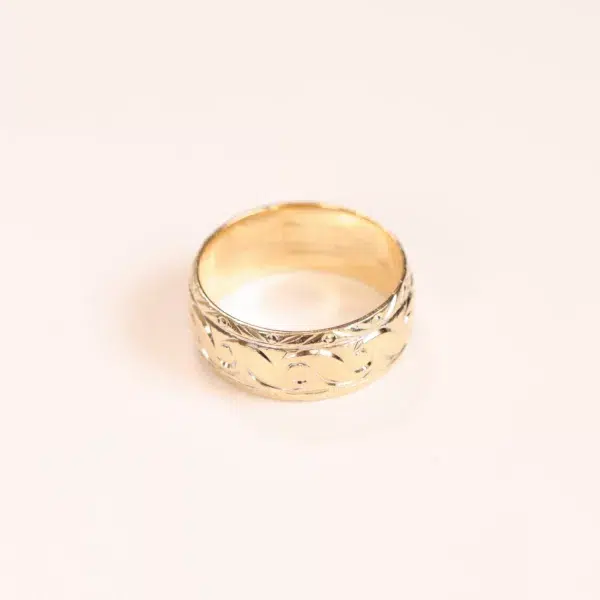 A 14 Karat Yellow Gold Comfort Fit Band ring with a pattern on it.