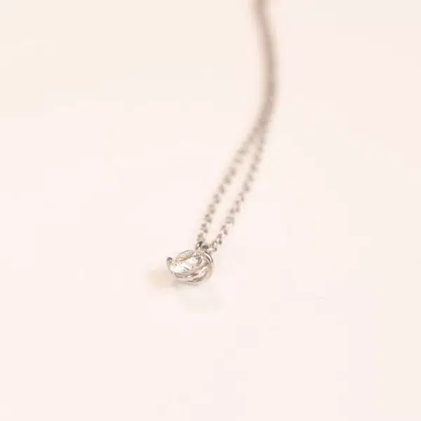 A silver necklace with a small diamond on a 14 Karat Yellow Gold Comfort Fit Band.