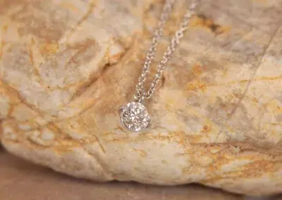 A silver necklace with a diamond on top of a 14 Karat Yellow Gold Comfort Fit Band.