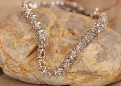 A silver bracelet with diamonds on top of a 14 Karat Yellow Gold Comfort Fit Band.