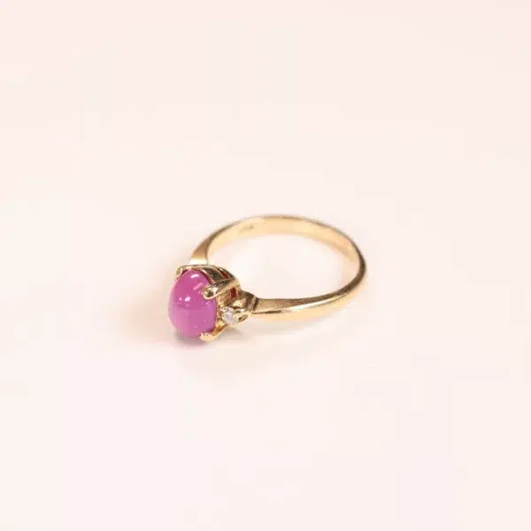 A 14 Karat Yellow Gold Comfort Fit Band with a pink stone.