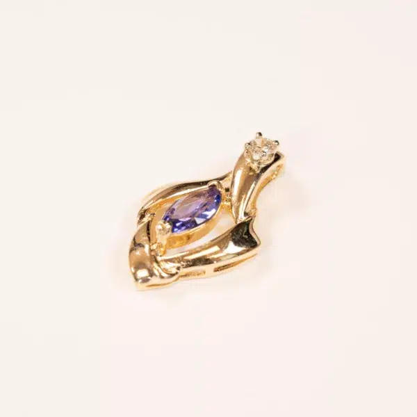 14K YG Tanzanite & Diamond Pendant in the shape of a swan, featuring a tanzanite gemstone and a small clear crystal, against a white background.
