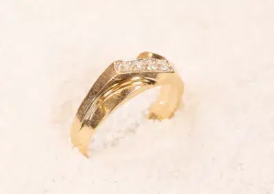 14K YG Diamonds & Peach Tourmaline Ring with inset diamonds and peach tourmaline on a white sand-like background.