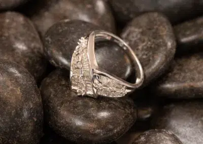 A 14K YG Diamonds & Peach Tourmaline ring, set on smooth, dark pebbles.