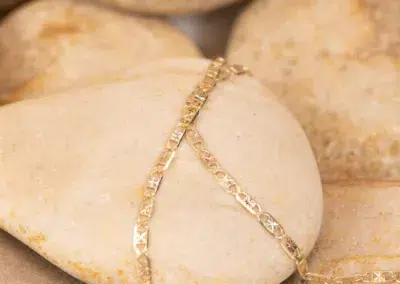 A delicate 14K YG Diamonds & Peach Tourmaline Ring with geometric designs resting on a smooth, peach tourmaline stone.